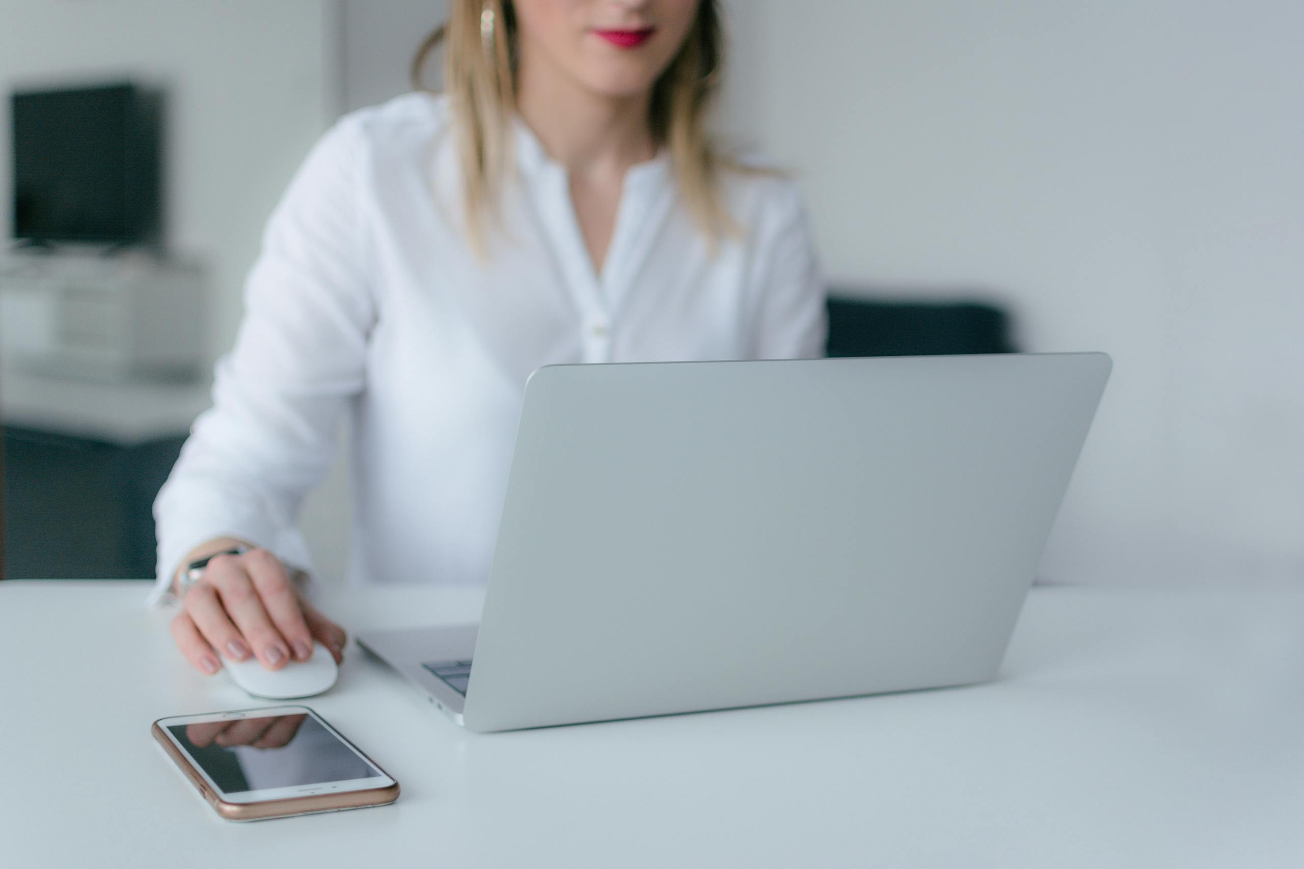 Woman Using Silver Laptop, the vibrant office setting. managed keycloak service, keycloak managed, managed keycloak, managed keycloak hosting